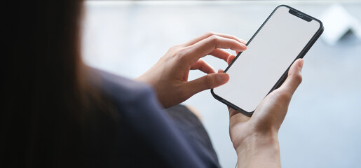 Close up view of businesswoman holding mobile phone with blank screen.