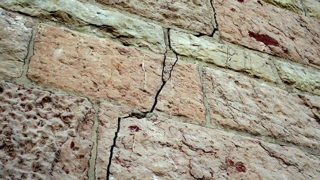 Cracked block old damaged wall. Crack close up