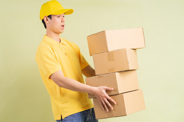 Asian delivery man is holding the carton with him and running to deliver the goods
