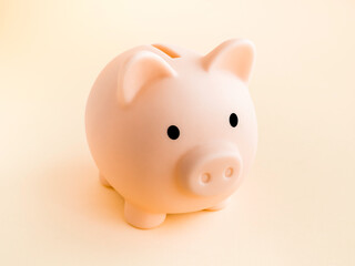 Cute piggy bank, pink color isolated on soft beige background. Saving money, Investment and finance concept.