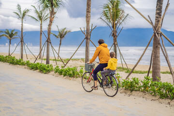 Fototapeta premium Father with his son having a weekend excursion on bike on a summer day in beautiful landscape
