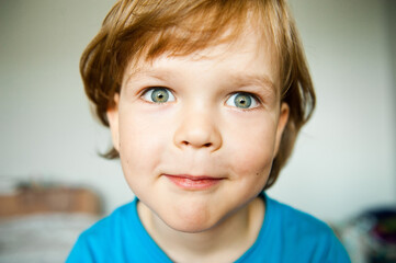 Funny portrait of a little boy looking into the camera.
