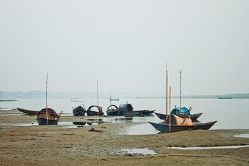 Some fishing boats are stationed on the dry river in winter.