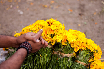 A salesman's hands are sitting with yellow flowers waiting for the sale.