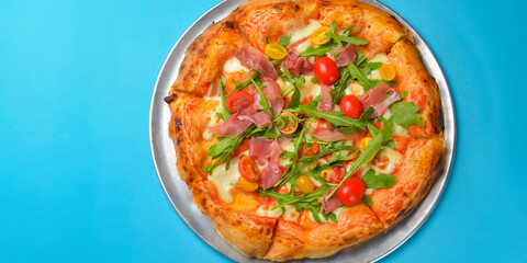 A Pepperoni pizza on a blue background isolated. Traditional Italian cuisine concept, pizza Margarita or Margherita