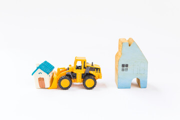 Obraz na płótnie Canvas Miniature house with front loader truck on white background, property business concept, new house, moving house