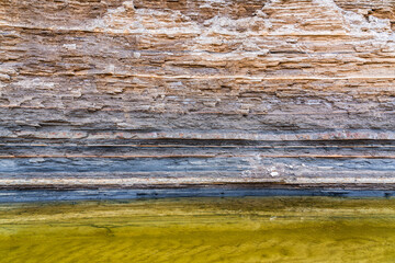 Rock layers above small mountain river - obrazy, fototapety, plakaty