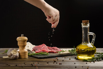 Obraz na płótnie Canvas Hand sprinkle salt on beef steaks.