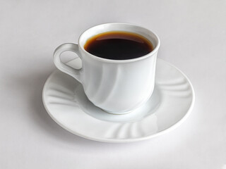 Cup of coffee on a white porcelain saucer