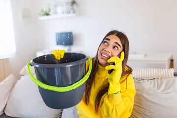 Shocked Woman Calling Plumber While Collecting Water Leaking From Ceiling Using Utensil