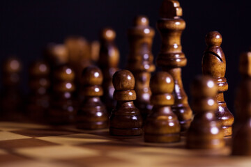 Wooden chess in a contrasting light. A game of chess, an intellectual competition,