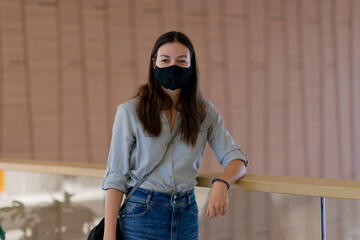 young woman in a reusable protective mask in a shopping center.