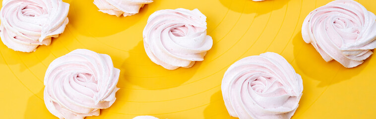 Pink marshmallow on a yellow background. Selective focus.