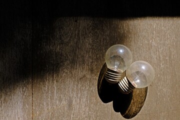 Fototapeta premium Old light bulbs on wooden floor with shadow from afternoon sunlight.