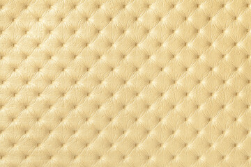 Texture of light yellow and golden leather background with capitone pattern.