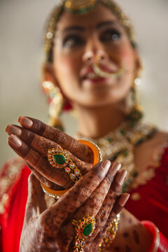  Indian Bride, wearing bangles and looking away 	