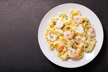 plate of pasta fettuccine with cream sauce and shrimps, top view