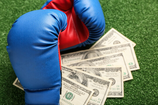 Money and boxing gloves on color background. Concept of sports bet