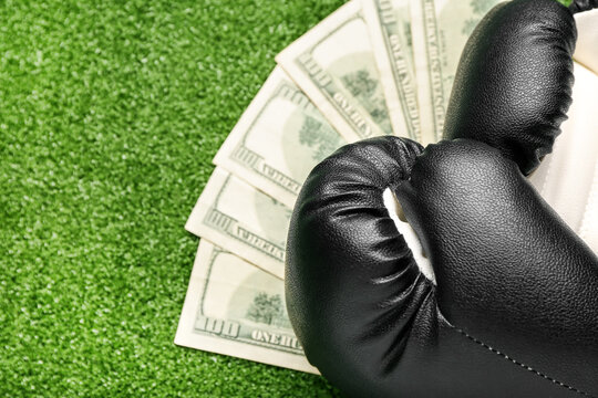 Money and boxing gloves on color background. Concept of sports bet