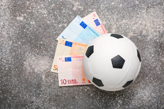 Money and soccer ball on grunge background. Concept of sports bet