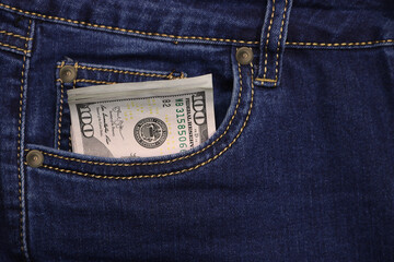 Stack of American hundred dollar bills in a pocket of blue jeans. Money in your pocket, cash.