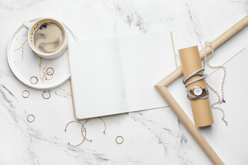 Stylish wristwatch, notebook and cup of coffee on light background