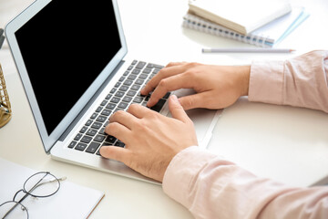 Young man working on laptop at table, closeup