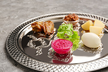 Passover Seder plate with traditional food on grunge background, closeup
