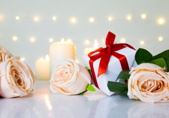 Love Valentine day theme with beige rose, gift box and candle on white background in bokeh light.