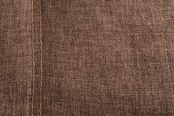 Textile surface with stitching. Textured brown background