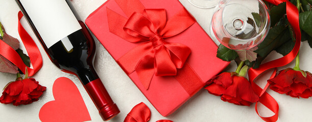 Concept of Valentine's day with roses, wine and gift box on white textured background