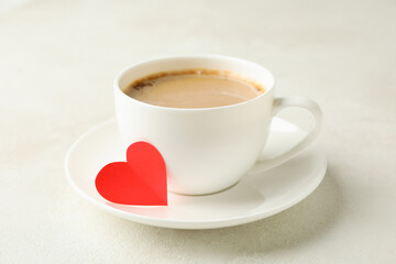 Cup of coffee with red heart on white textured table