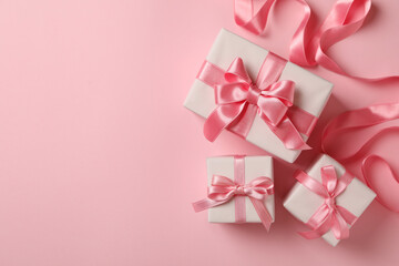 Gift boxes and ribbon on pink background