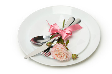 Plate with cutlery, pink bow and rose isolated on white background
