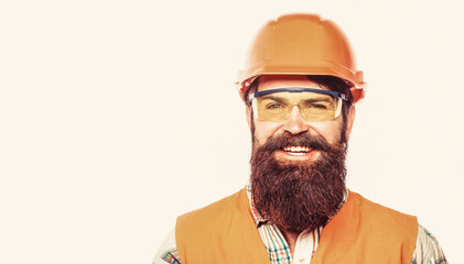 Man builders, industry. Builder in hard hat, foreman or repairman in the helmet. Bearded man worker with beard in building helmet or hard hat. Portrait of a builder smiling - obrazy, fototapety, plakaty