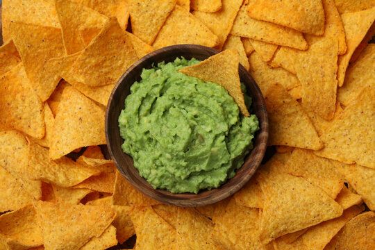 Bowl Of Guacamole On Chips Background, Top View