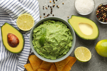 Concept of tasty eating with guacamole and ingredients on gray background