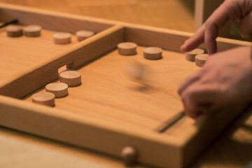 Wooden bard game where you shoot round wooden blocks through opening with help of an elastic band....