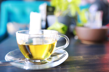 Hot steaming green tea in a cup on a rustic background