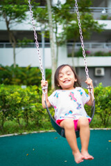 Active little toddler child playing swing at the playground. Happy and fun time.