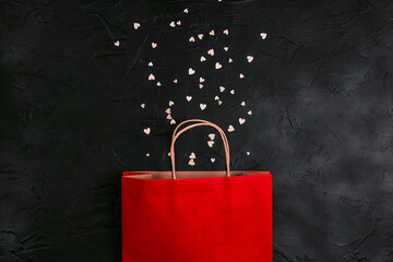 Red shopping bag with little hearts on black background.