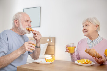 Senior couple having breakfast and looking contented