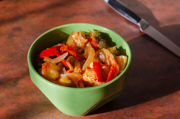 Canned homemade food concept. Canned vegetable salad in a green bowl on the kitchen table.