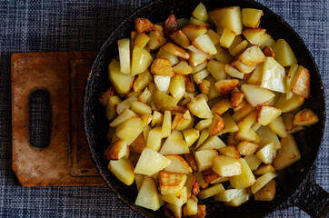 Pan fried potatoes on a wooden cutting board.
