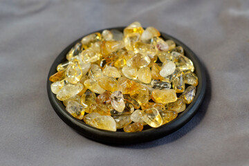 Citrine yellow gem geode crystals geological mineral on black plate as nice background close up
