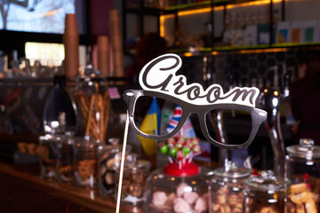 Birthday and Party Set and Weeding. Fun glasses with the inscription groom on a cafe background.