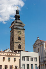 Fototapeta na wymiar traditional European buildings and a tower with a copper dome and a clock on a sunny day in Jicin, Czech Republic.