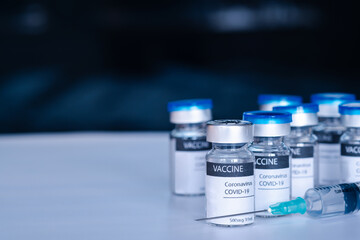 Covid-19 vaccine and syringe injection on a laboratory bench. to fight the coronavirus sars-cov-2 pandemic. Medicine infectious concept.