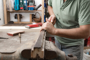 Male carpenter working on old wood in a retro vintage style.