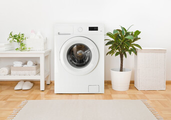 Modern washing machine, towels and related objects in laundry room - obrazy, fototapety, plakaty